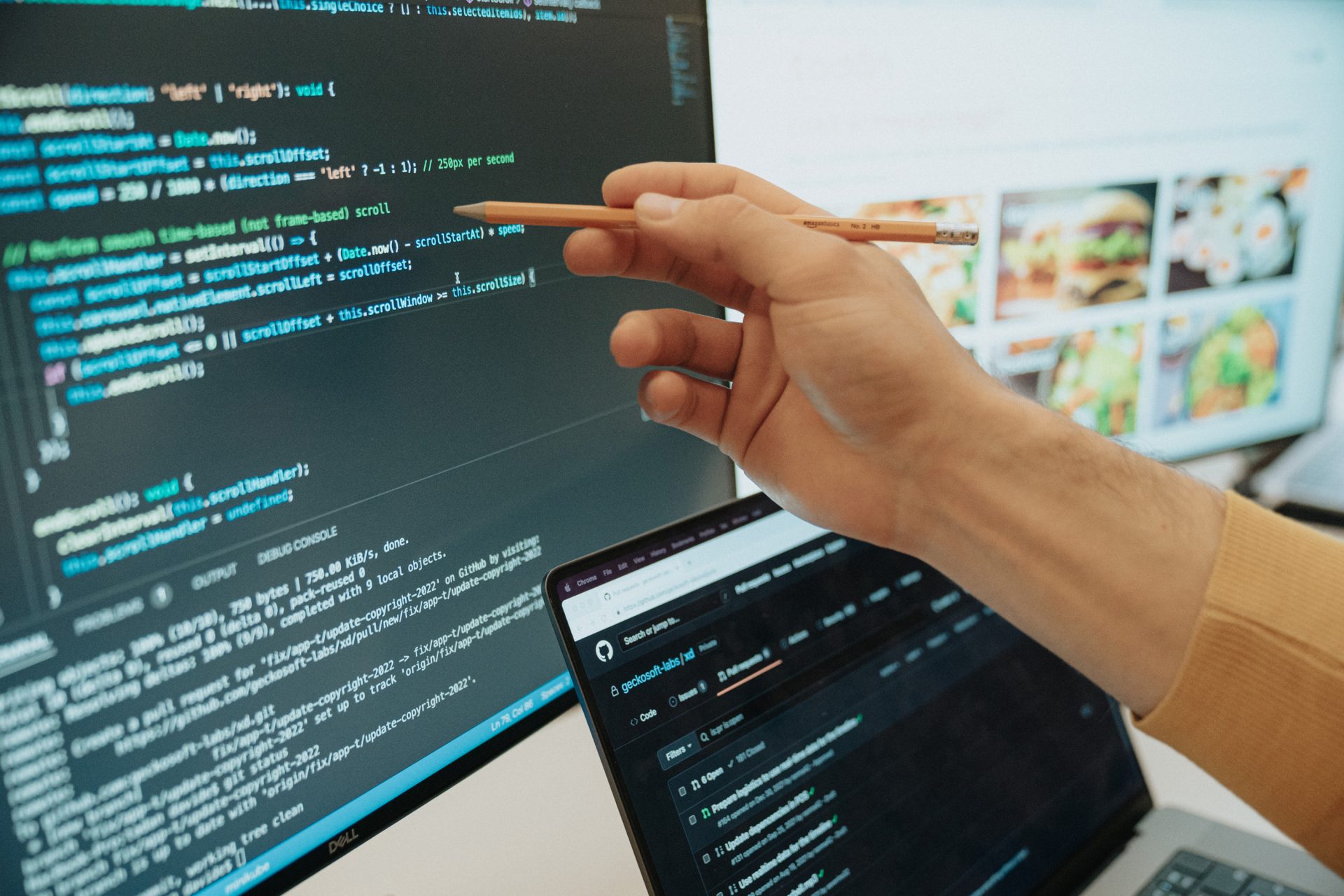 Una mano di una persona che impunga una matita e indica una riga di codice su uno schermo di un computer